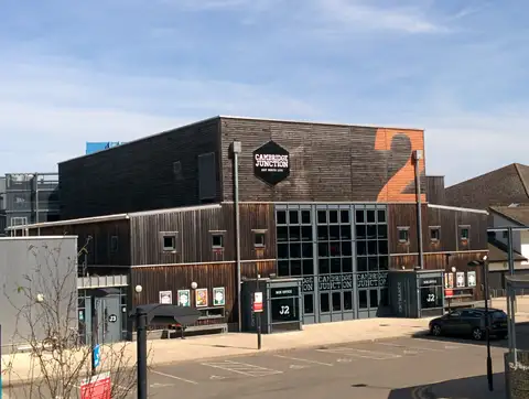 The timber-clad Cambridge Junction building with its glass entrance on a quiet afternoon